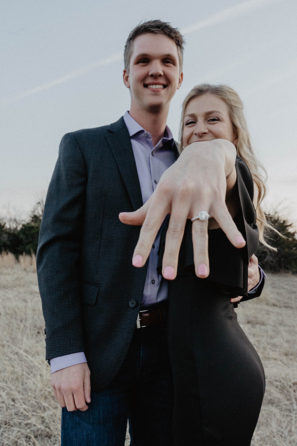 beautiful smiling couple show off their diamond engagement ring