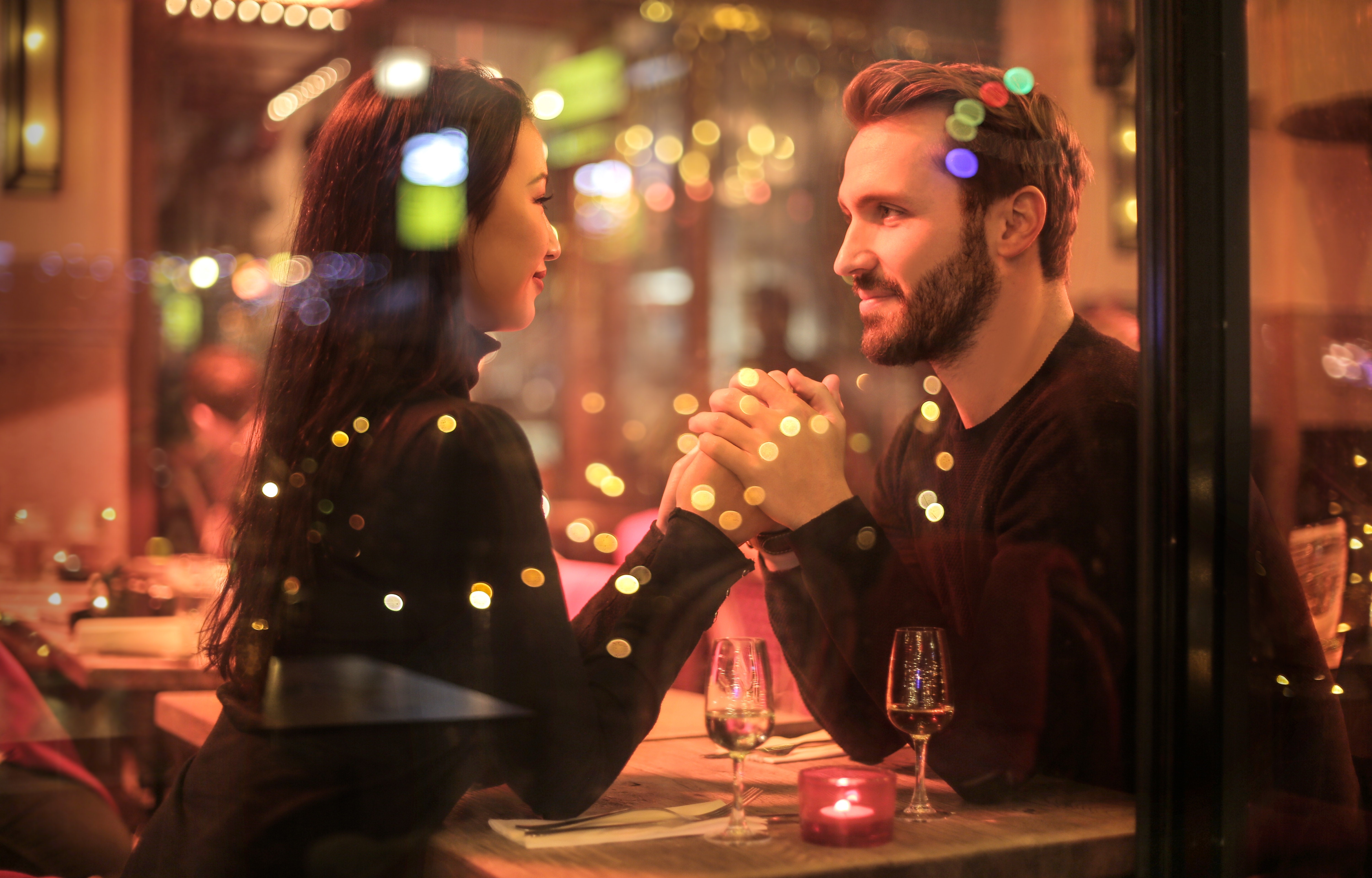 Window at diner with man holding woman's hands