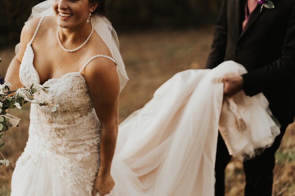 Woman in wedding dress with train being held