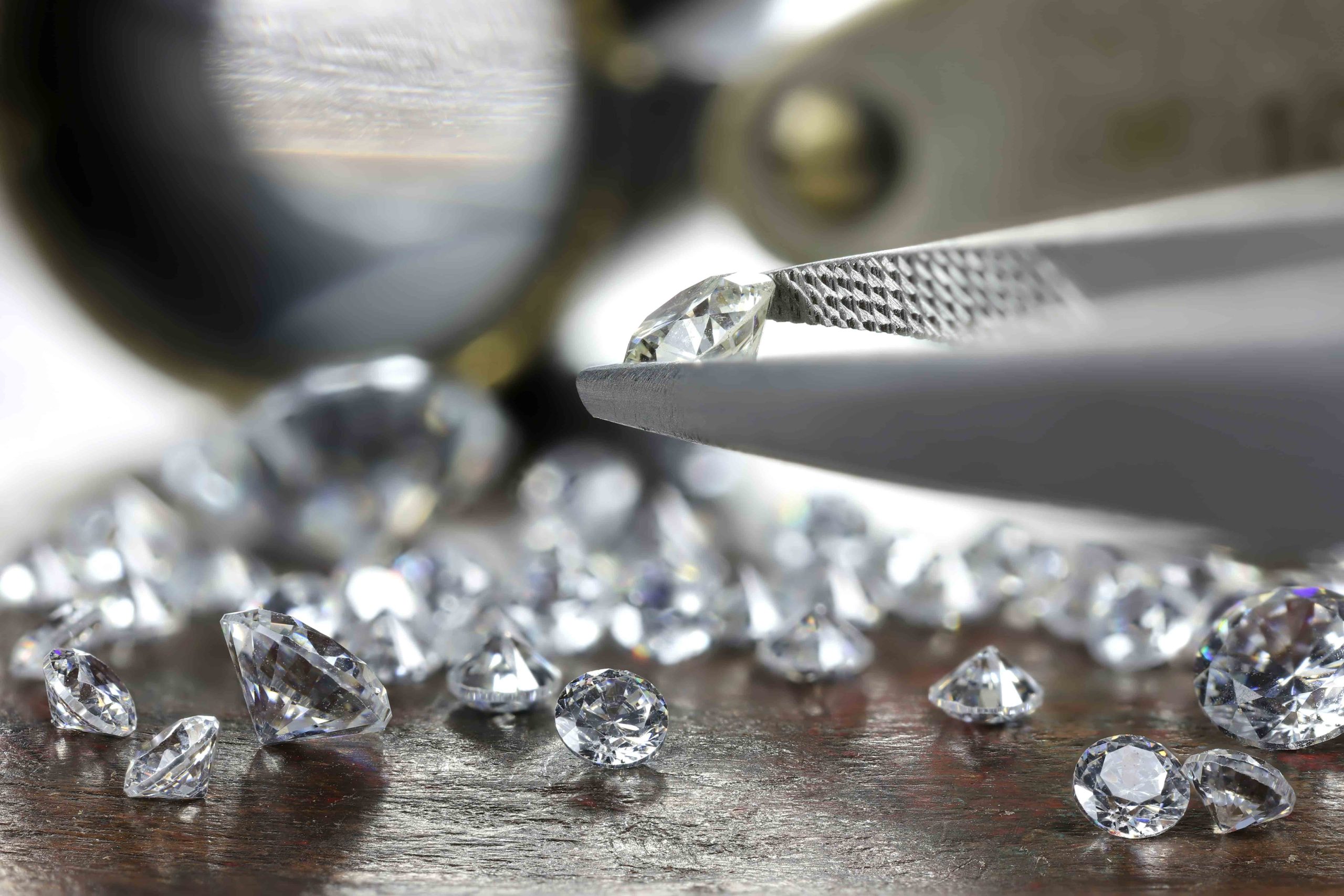 loose diamonds being held by tweezers
