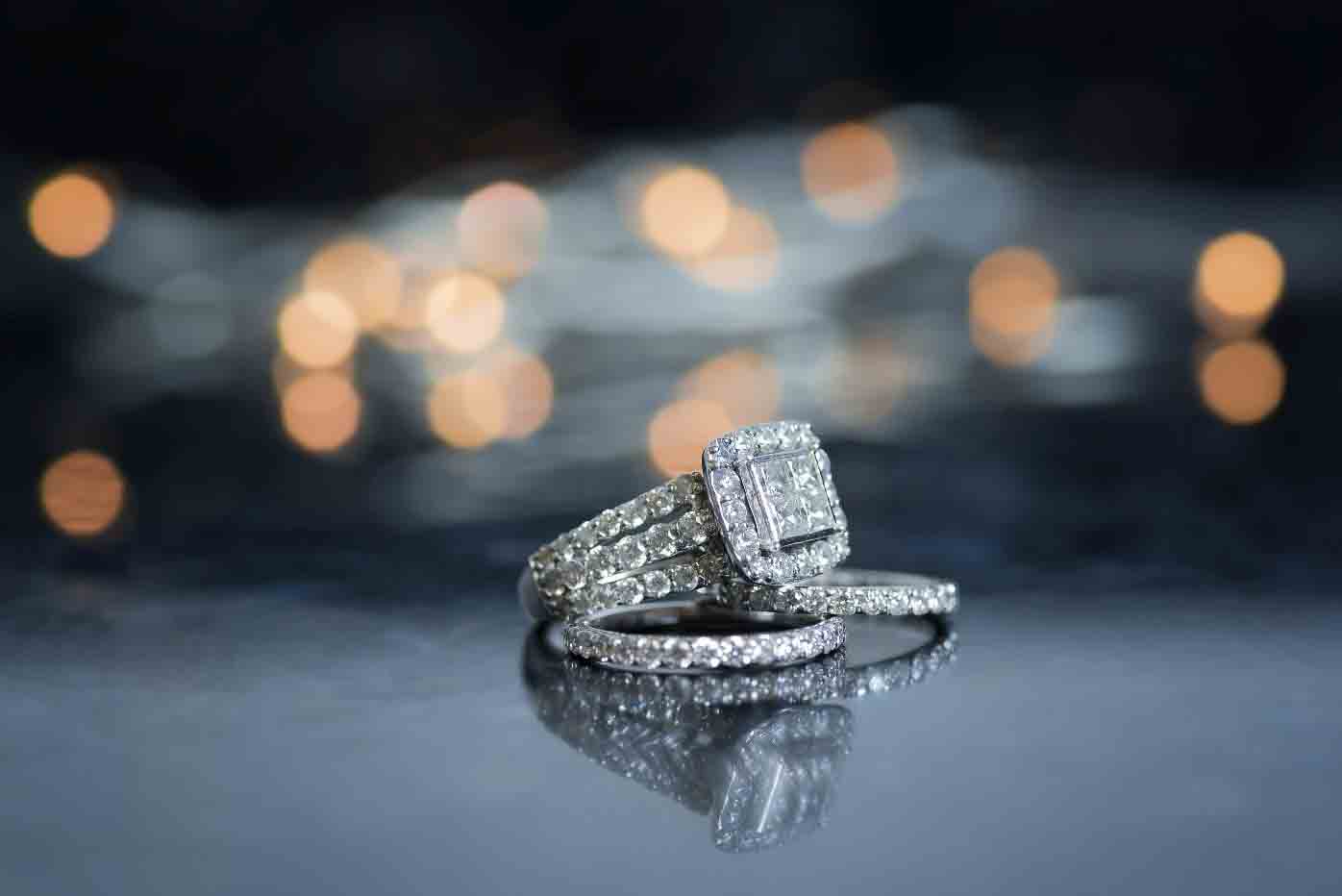 couples holding hands with engagement rings